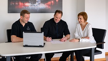 Leistungen Mitarbeiter des Autohaus Greppmair sitzen am Tisch eines Meetingraumes